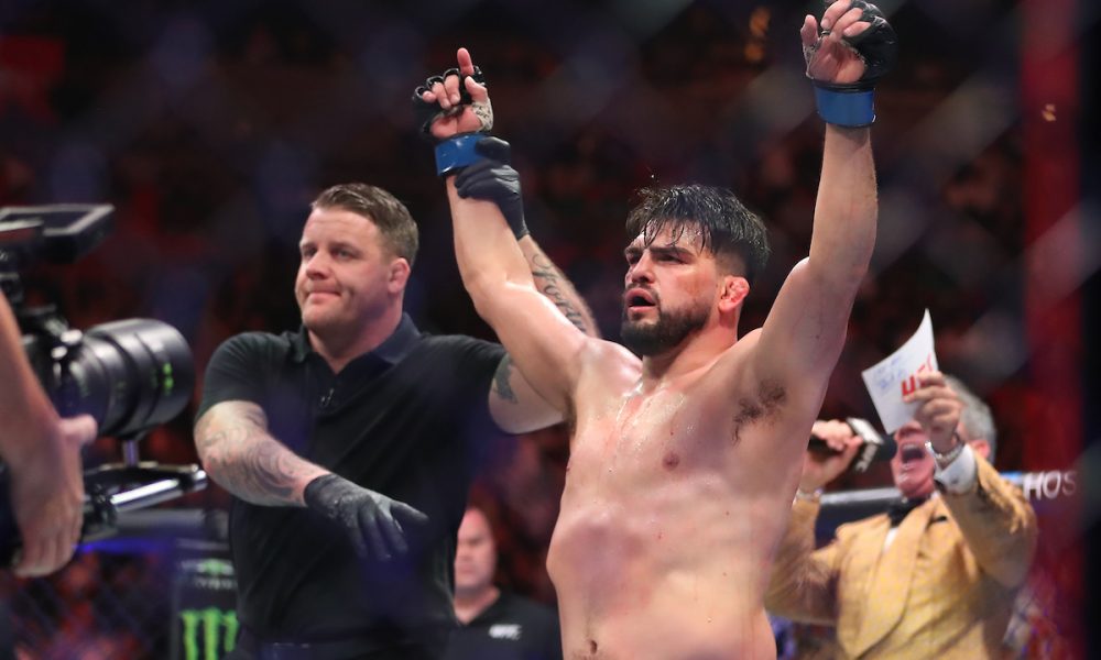 Com os braços erguidos, Kelvin Gastelum é anunciado como vencedor da luta contra Chris Curtis no UFC 287