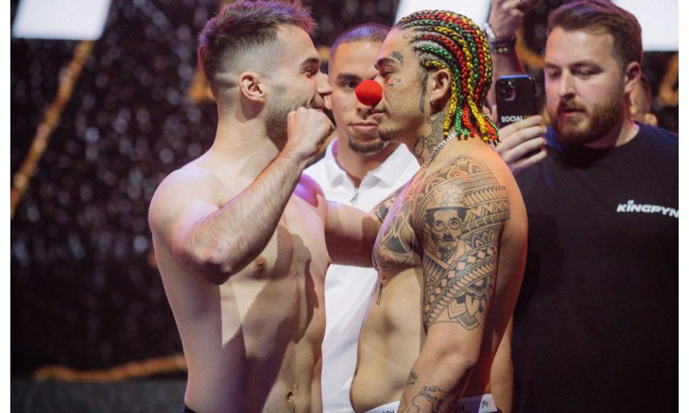 Com tranças coloridas e um nariz de palhaço, comediante brasileiro debocha das provocações do rival