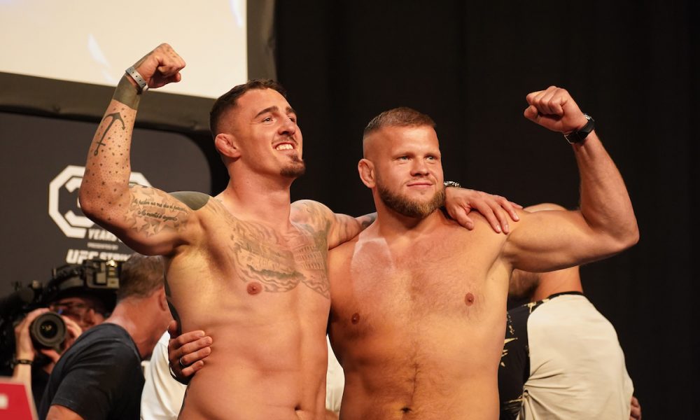 Tom Aspinall e Marcin Tybura se abraçam na pesagem cerimonial do UFC Londres.
