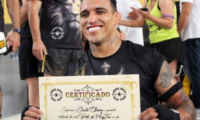 Charles do Bronxs posa para fotos após receber o certificado de grau preto de muay thai