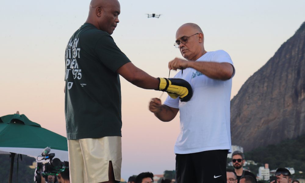 Anderson Silva observa o treinador Luiz Carlos Dorea ajustar suas luvas antes do treino aberto para sua luta de boxe contra Chael Sonnen