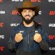 De chapéu de cowboy, Bruno Lopes sorri para foto durante o media day do UFC Vegas 107
