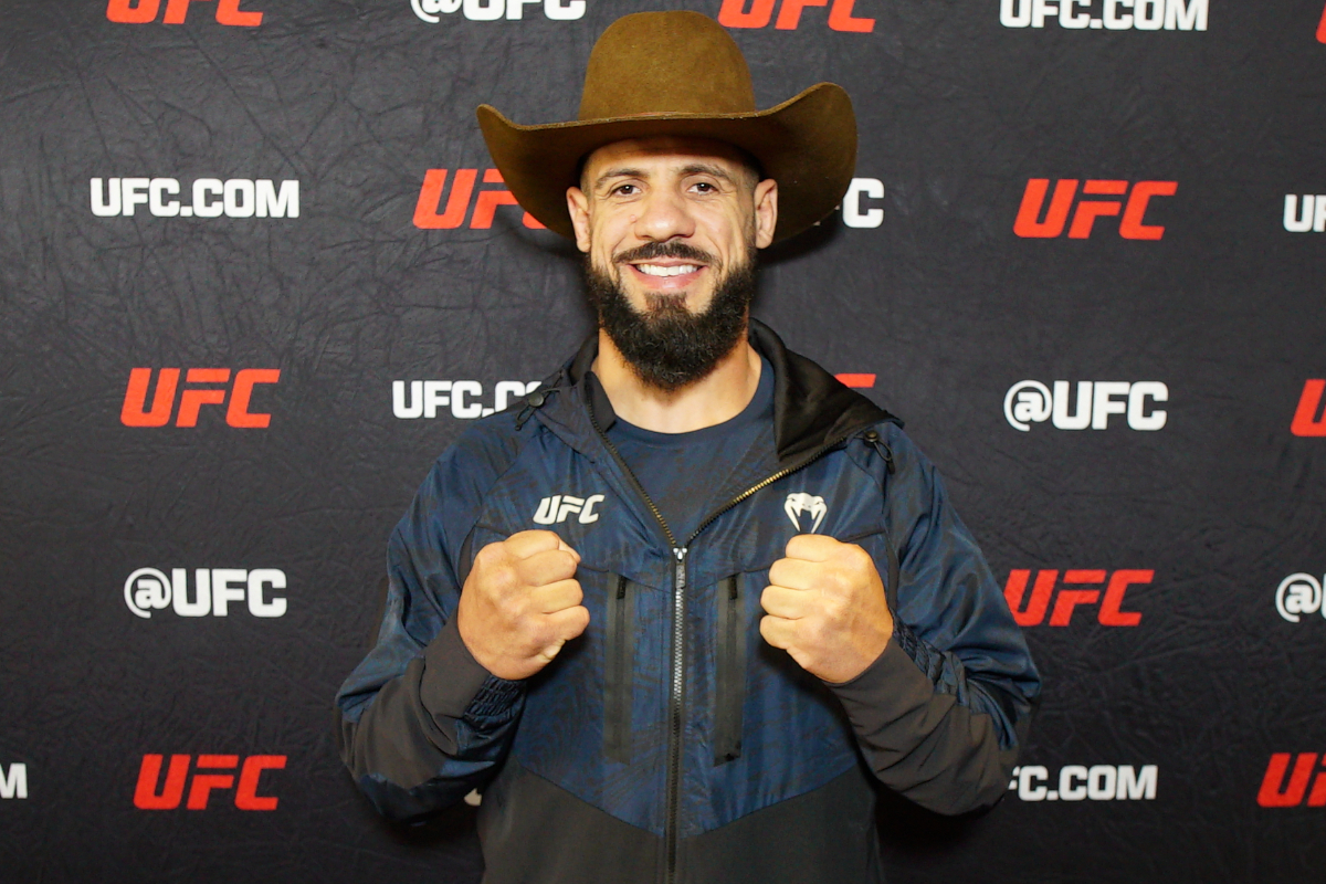 De chapéu de cowboy, Bruno Lopes sorri para foto durante o media day do UFC Vegas 107