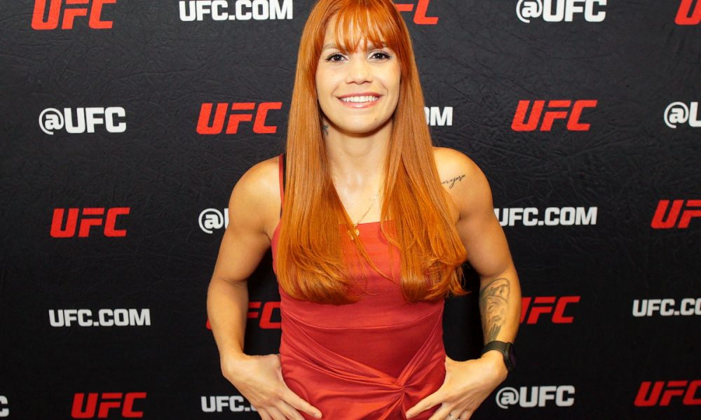 De vestido vermelho e sorriso no rosto, Rayanne dos Santos posa para foto no media day do UFC Vegas 107