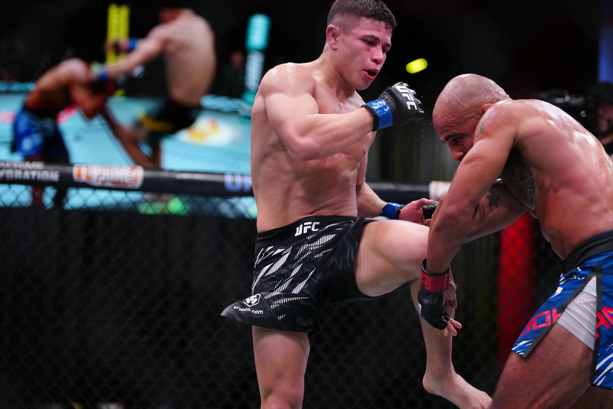 Miles Johns e Jean Matsumoto desferindo joelhada voadora em Miles Johns no UFC Vegas 109