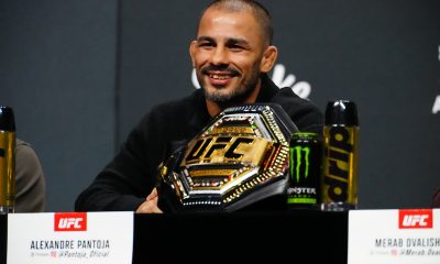 Alexandre Pantoja sorri ao lado do cinturão na coletiva do UFC 323