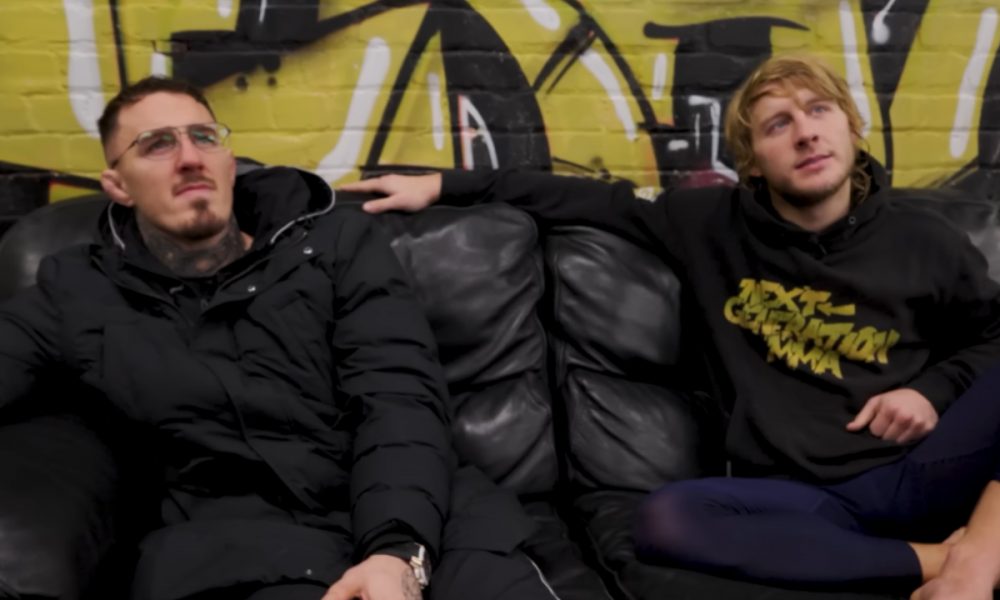 Tom Aspinall e Paddy Pimblett sentados num sofá