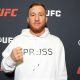 De casaco branco, Justin Gaethje posa para foto no media day do UFC 324