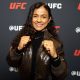 De punhos cerrados e sorriso no rosto, Natália Silva posa para foto no media day do UFC 324